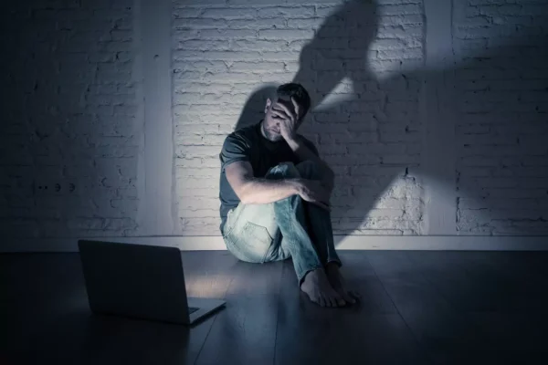 Porn Addiction: Understanding, Effects on Youth, and Breaking Free A man hides his face in shame from a computer screen in a dark room. People may use sex and pornography to activate a “pleasure system high” that can lead to a deeper progression of porn addiction.